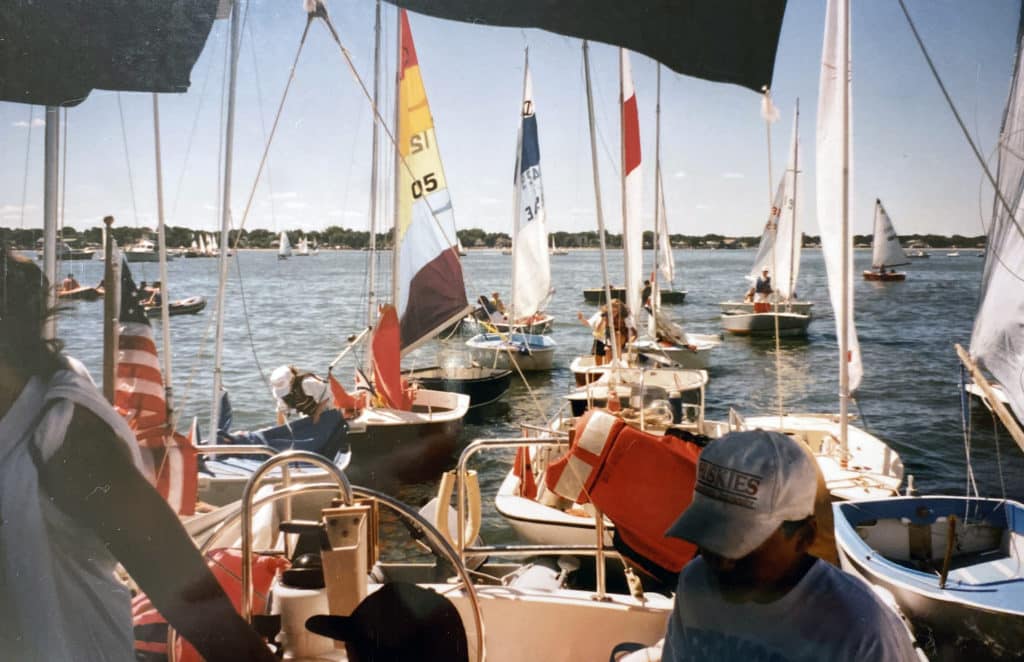 colorful junior sailboats being towed behind a powerboat in the late 1980s