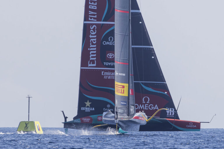 two AC75 America's Cup yachts crossing on the waters off Barcelona, Spain