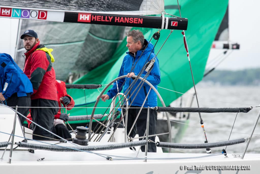 Man on sailboat with green sail