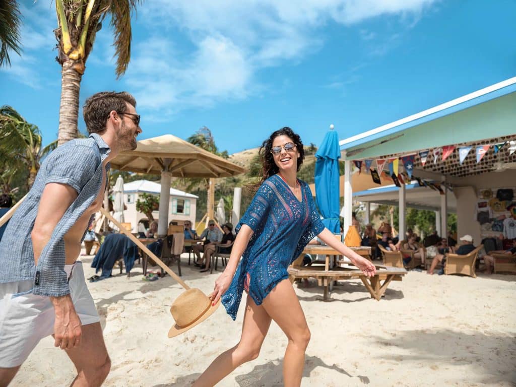 A couple walk past the Soggy Dollar bar on Jos Van Dyke in the British Virgin Islands.