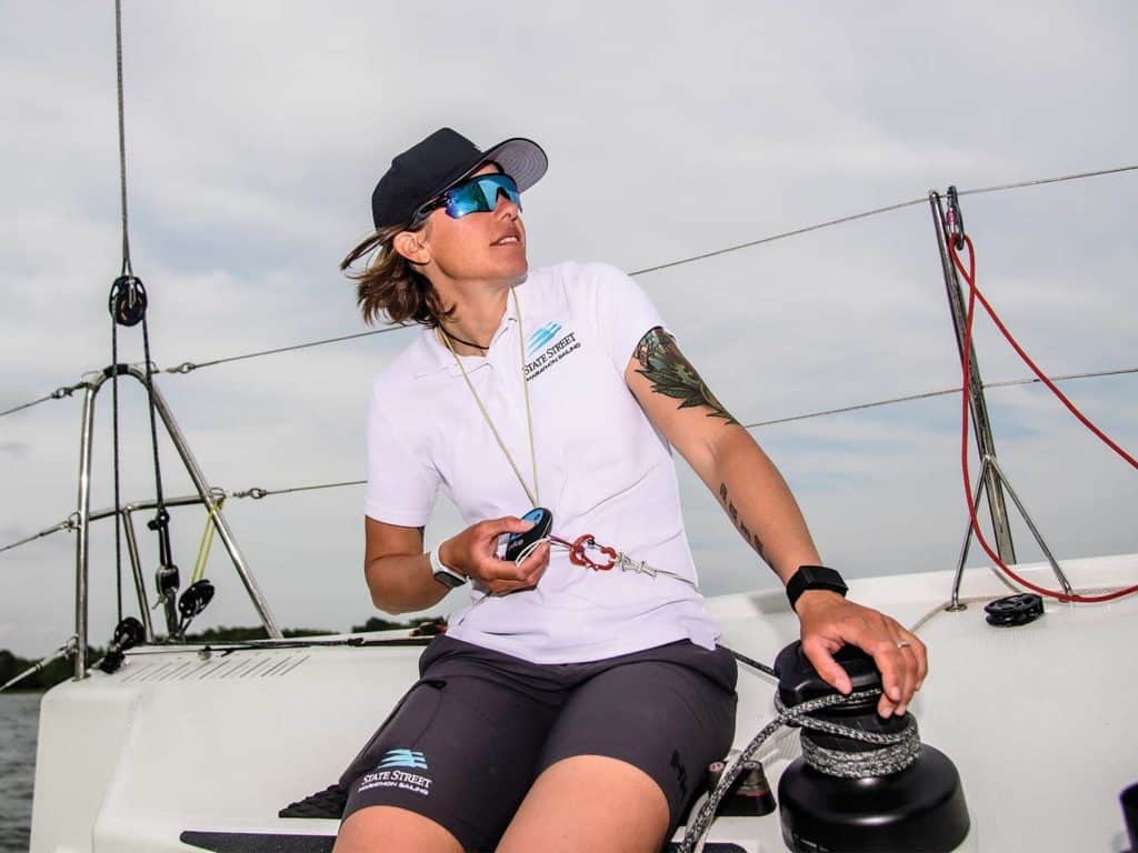 A woman working on a sailboat rigging.