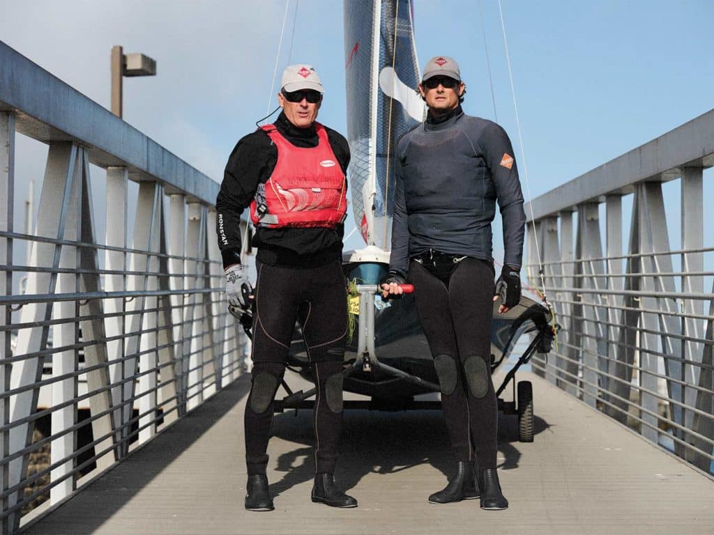 Two men standing on a small walkway.