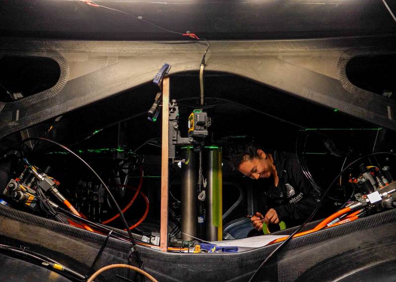 Mechatronics Engineer Kelly Hartzell takes measurements inside the first AC40 delivered to Emirates Team New Zealand.