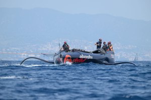 Alinghi Red Bull Racing's sailing team returns to base with a section of its broken spar on board Boat One.